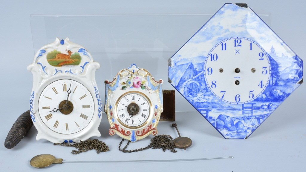 Lot of 3 Antique Clocks: Nice lot with two porcelain face German clocks, along with a porcelain on metal clock. Missing some parts, and in need of repair. Larger German clock with stag has a crack in the left side. All three 