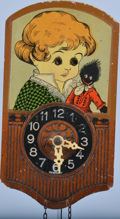 German Blinking Eye Clock with Gollywog: Great early clock depicting young girl and her Gollywog doll. Marked Germany at bottom of clock face, Made of wood with some embossed details. Includes original weight and pendulum which is chipped. S