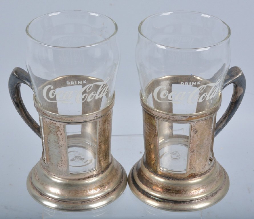 2 VINTAGE COCA COLA GLASSES IN SILVER HOLDERS: Nice lot of vintage Coca Cola glasses in silver plated holders. Glasses say Drink Coca Cola. Measure 5 1/2" high. Excellent
