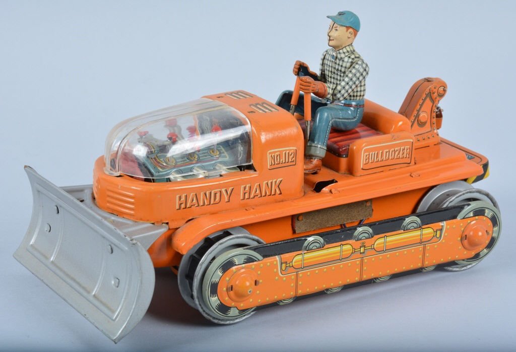 JAPAN Battery Op HANDY HANK BULLDOZER: Nice battery op Dozer with nice colors and original driver. Missing 1 rubber track. Battery box has corrosion. 11" long. Good