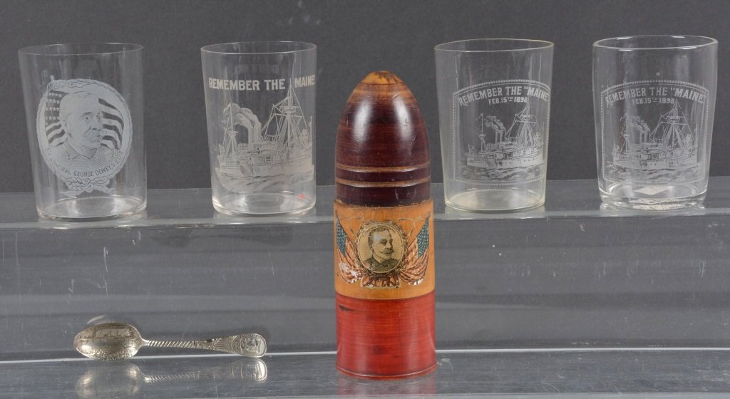Lot of 6 Spanish American War Adm. Dewey Items: Great lot with wood bank in the shape of a artillery shell, 4 glasses commemorating Admiral Dewey and the Maine, along with a silver spoon with Captain Sigsbee and the Maine Battleship. Excellent