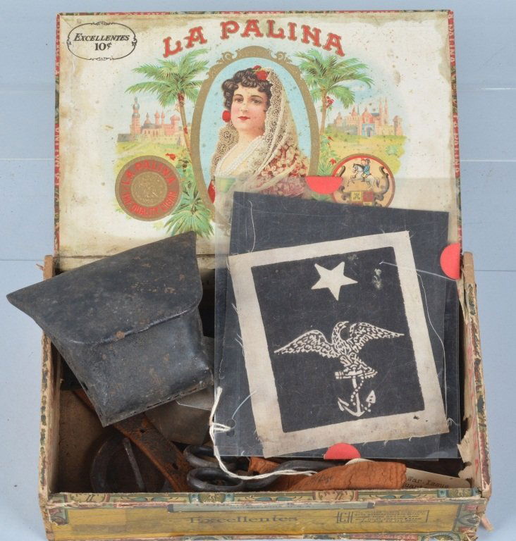 Lot of Military Items & More, in Wood Cigar Box: Interesting grouping with 1864 dated wick cutter, unusual tin percussion cap box, a Civil War Quartermaster at Arms sleeve patch, and more. Good-Very Good