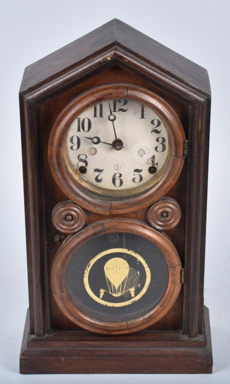 ANTIQUE SHELF CLOCK WITH BALOON & FLAGS: 16" by 9", face has wear and loss, interesting case with round door, original glass with gold hot air balloon and flags. Good-Very Good