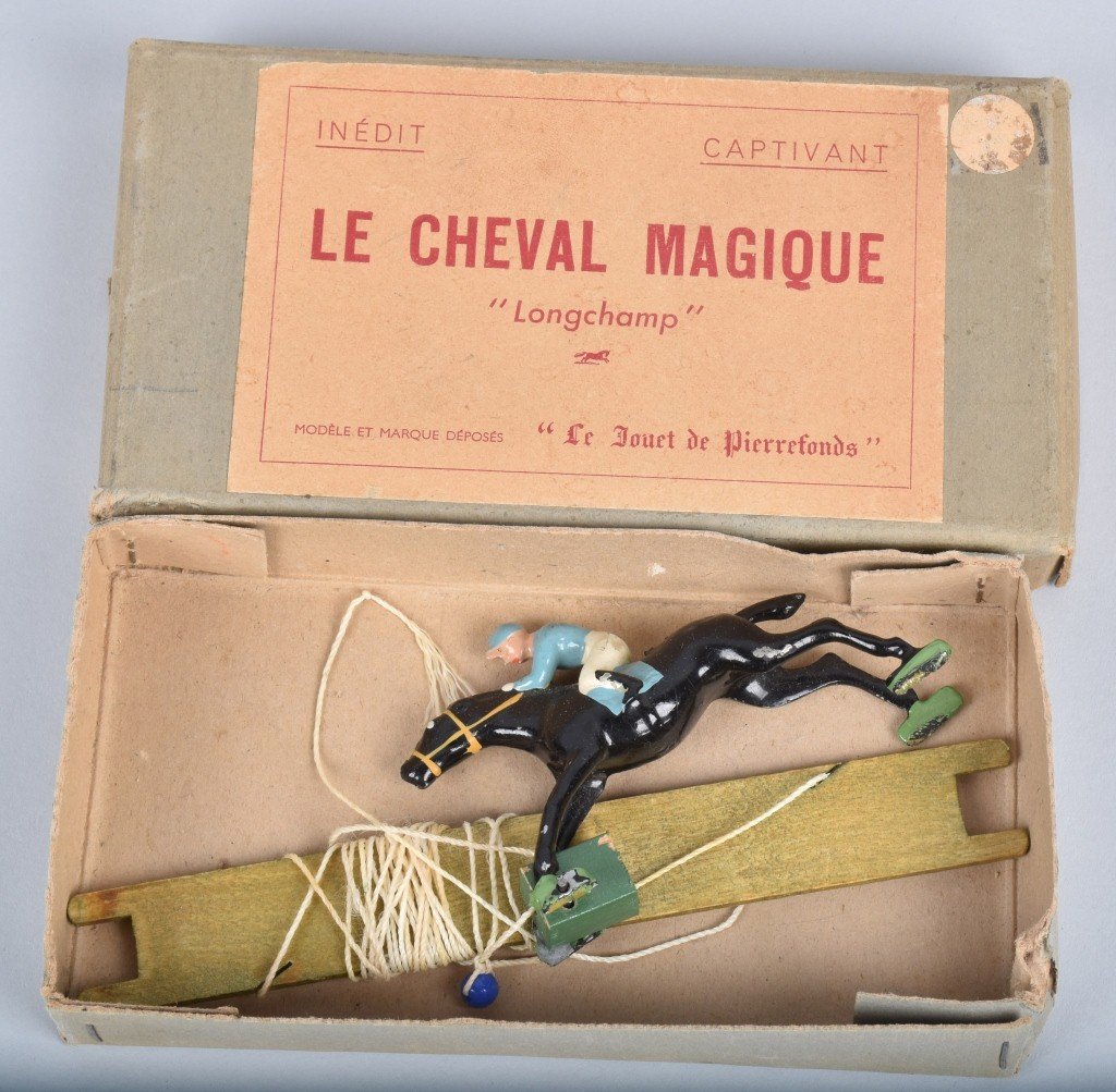 LE CHEVAL MAGIQUE "LONGCHAMP" CAST RACE HORSE: Excellent cast metal race horse with jockey with string and paddle. With original box. 7" Excellent