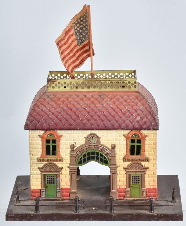 GERMAN BING 1920'S HAND PAINTED TELEGRAPH STATION: Base is 10" by 6 1/2", and building is 8 3/4" high, handpainted with tin litho window and door frames, has early cloth flag on top, early Bing logo tag on base. Has general wear, and should clean to a