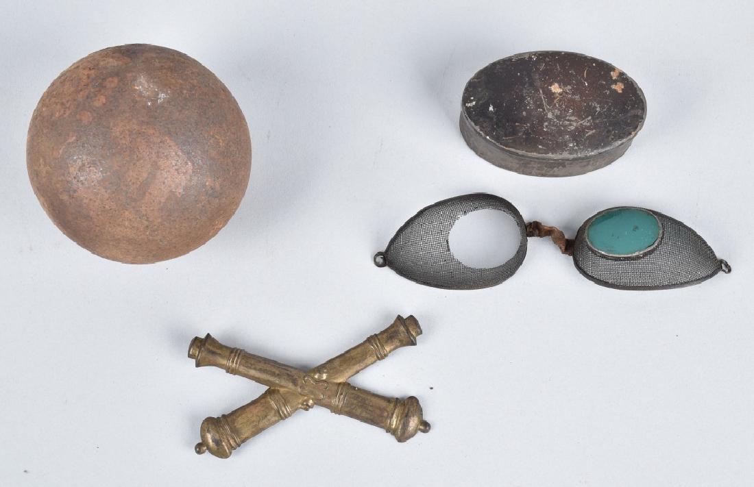 CIVIL WAR ARTILLERY LOT, CANNON BALL & MORE: Lot includes 3" solid shot cannon ball, blue lens artillery glasses in the original tin, and 3 1/2" crossed cannon hat device. Glasses are missing one lens. Condition varies.