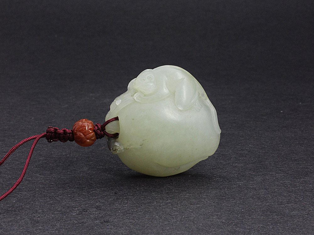 Nephrite jade pendant Qing Dynasty: 清 白玉靈猴獻壽 With carving of a monkey clinging to a peach. 1.63in. (4.1cm.)L