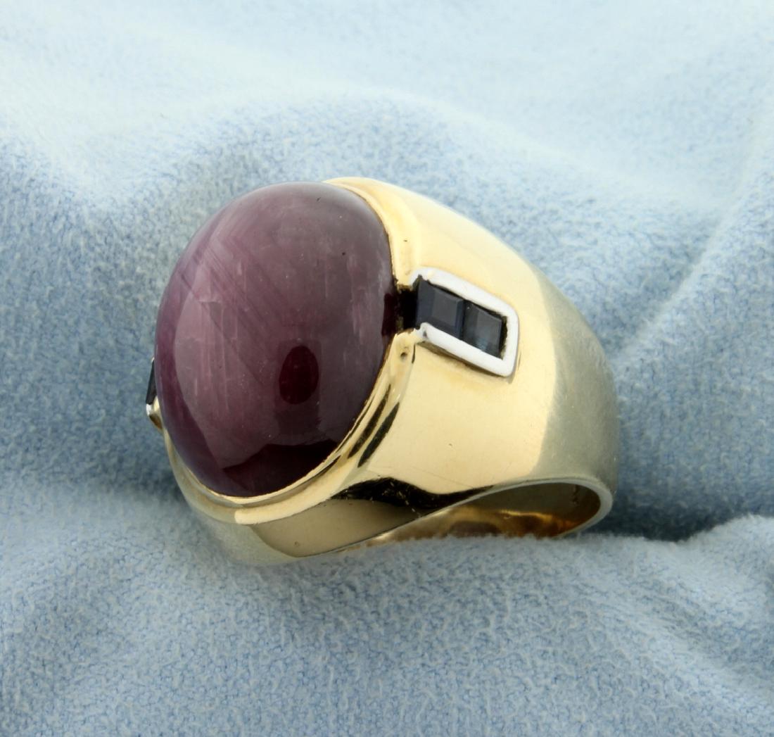 Purple Cats Eye Ring: In 14K yellow gold there is a 20x16mm purple cats eye cabochon gemstone. Also this ring contains four 2.5mm square blue chrysoberyl gemstones in shank. Size 9 1/2 20.7g