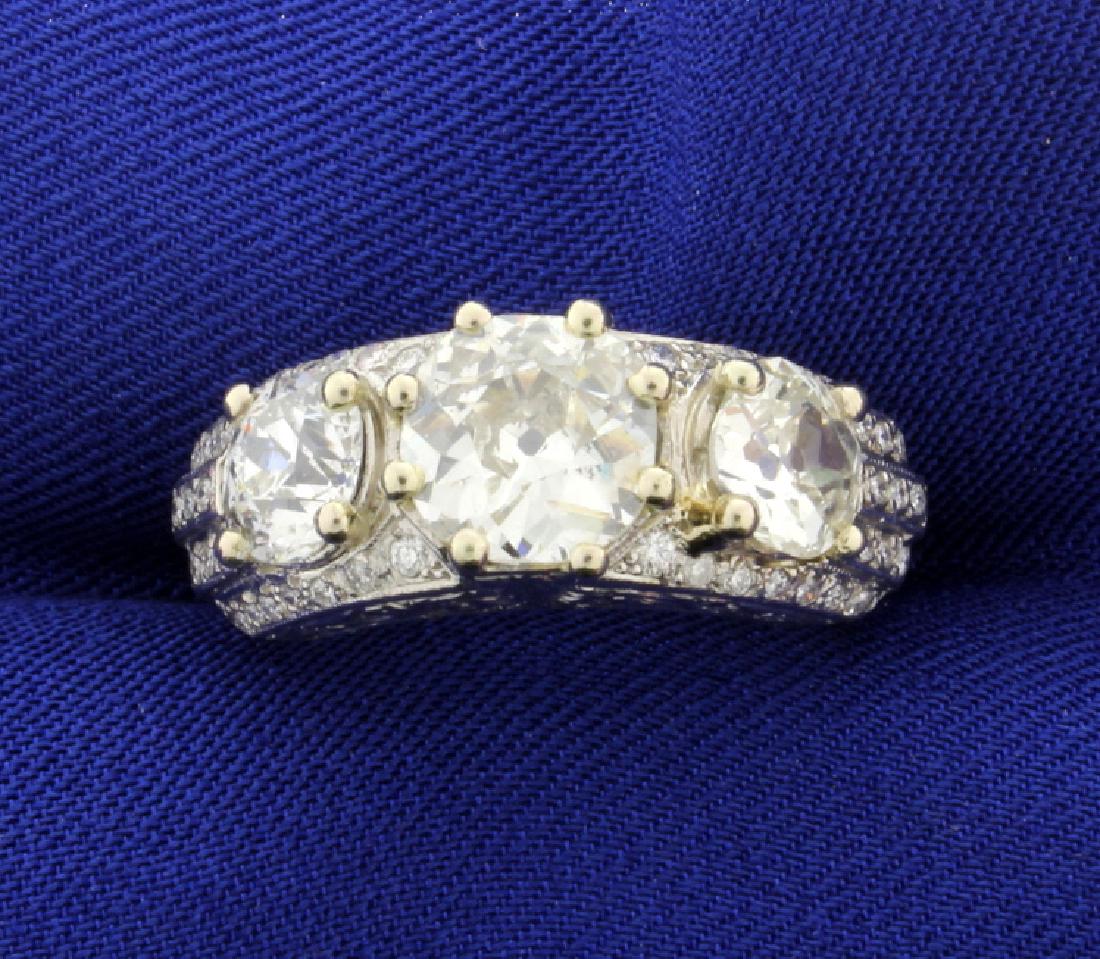 Antique 4.5 CT Total Weight Diamond Ring in Platinum: Three old style cut diamonds, center is 2ct, side diamonds are 1ct each. Diamonds are SI clarity, M color surrounded by 1/2ct TW of diamonds. Platinum mounting, size 6 1/2. 10.1g