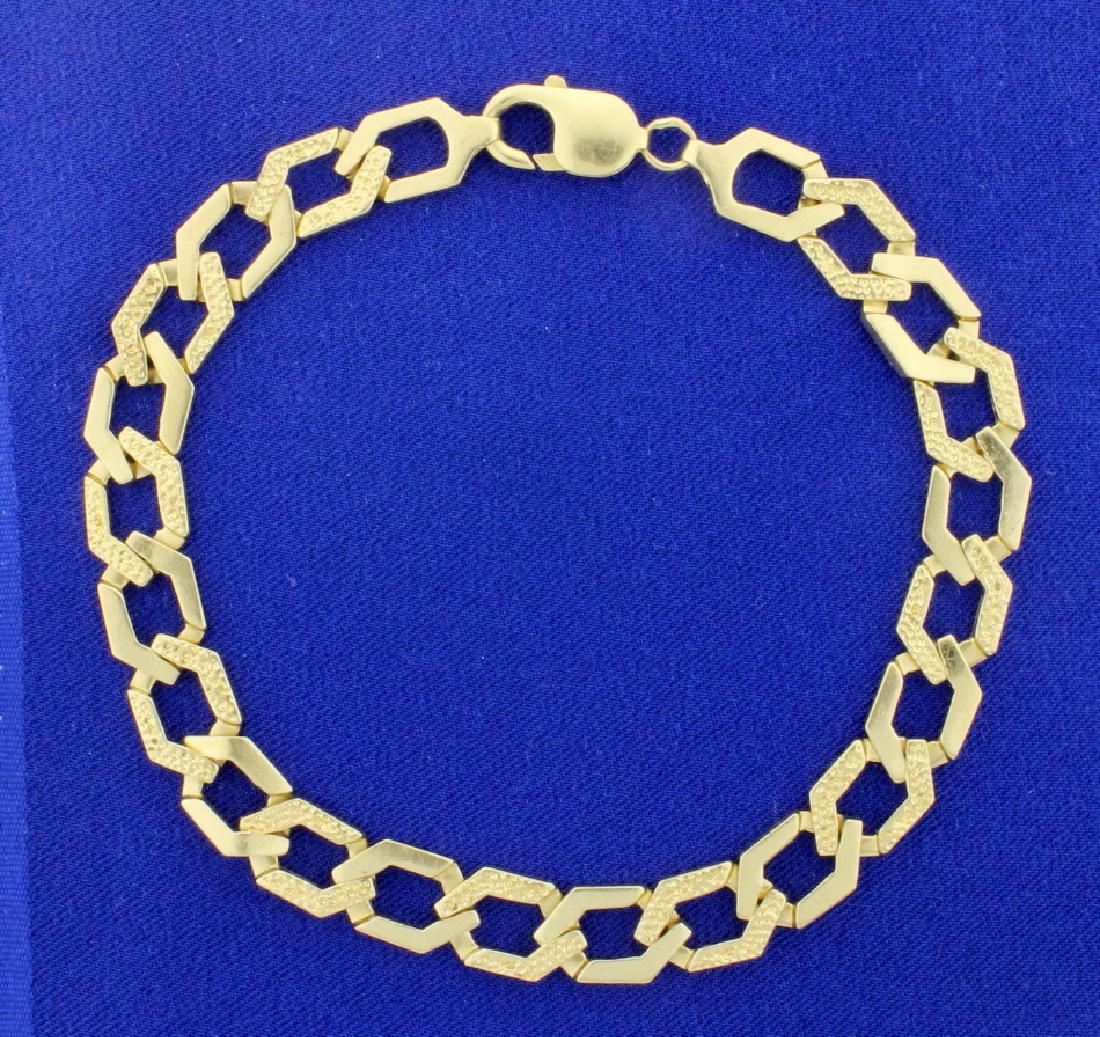 14K Heavy Curb Link Chain: In 14K yellow gold this bracelet is 10 1/4 inches long and 9 1/2mm wide. With lobster clasp. 29.3g
