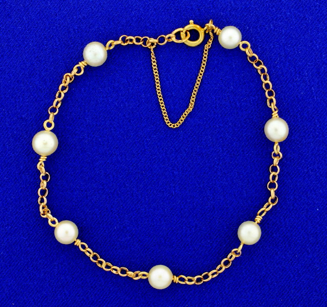 Cultured Pearl & 18k Gold Link Bracelet: 7 Cultured pearls measuring 5.75mm each are set between 18k solid yellow gold links in this 7" long chain. Pearls are high quality with excellent color and luster. With a safety chain. 4.7g