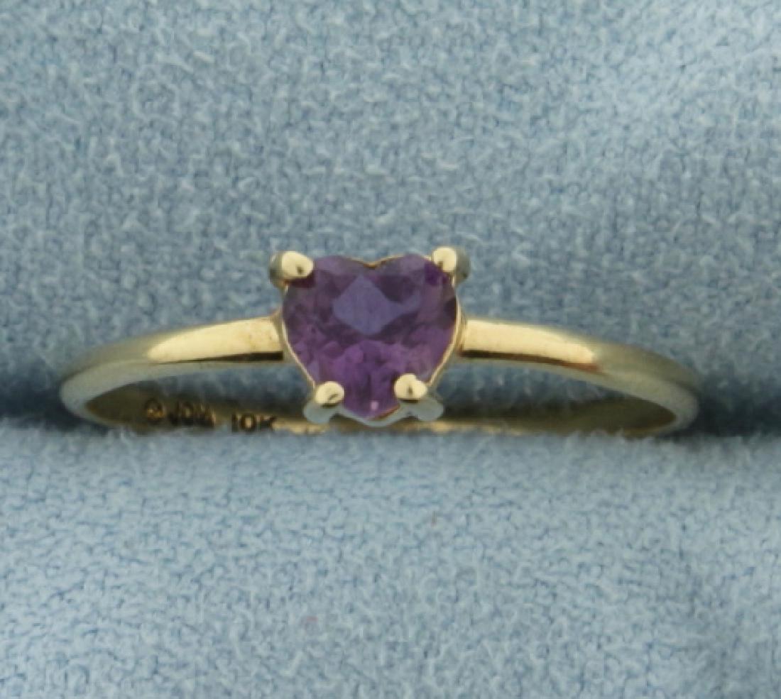 Solitaire Amethyst Heart Ring: In 10k yellow gold. Containing a natural .35ct natural amethyst gemstone shaped like a heart with a deep purple color and excellent clarity. Size 7. 0.9g.