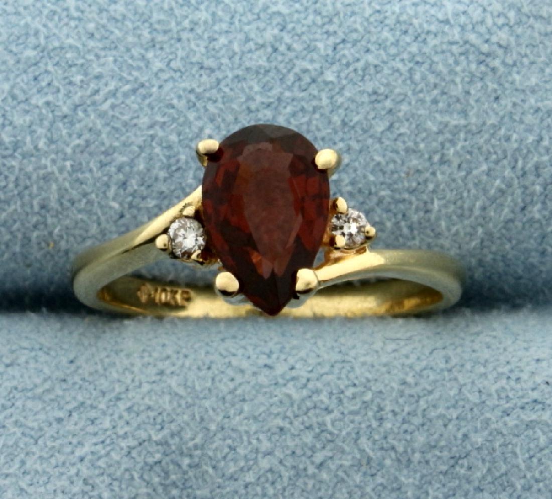 Garnet and Diamond Ring: In 10k yellow gold. Center stone is a natural pear shaped 1.5ct garnet with beautiful orange red color and excellent clarity. Also contains two high quality .01ct diamonds, VS clarity/H color. Size 6 