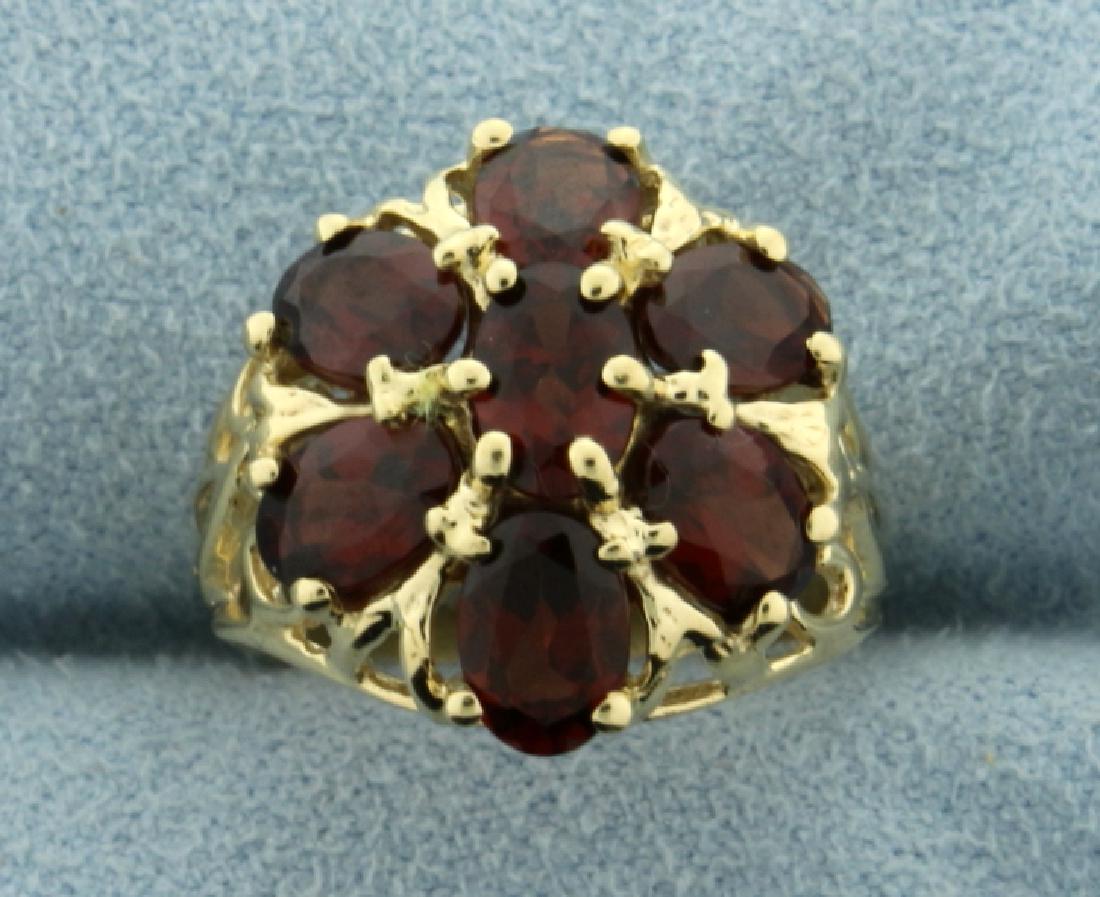 3 1/2ct TW Garnet Flower Ring in 14K Yellow Gold: In 14K Yellow Gold. Contains seven 6x4mm high quality natural oval Garnet gemstones with excellent clarity and beautiful red color with hint of orange. Size 5 1/4. 3.8g