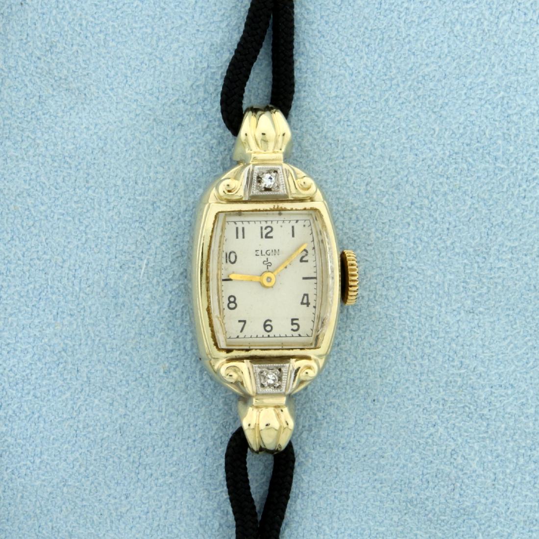 Antique Women's Elgin Watch in Solid 14K Yellow Gold: Case in Solid 14K Yellow Gold. Contains two high quality .01ct round diamonds on bezel. Windup movement runs great. 7 3/4 inches long, with safety clasp and chain. 13.0g