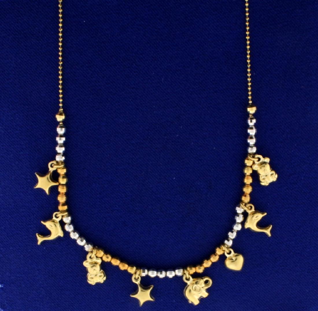 Animal Charm Necklace in 14k Gold: 14k gold animal charm necklace with 8 charms including dolphins, teddy bears,elephant, hearts, and stars. Alternating yellow and white gold beads on necklace gives a unique look. 16 inches long. 14k l