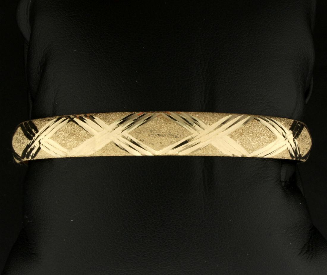 Diamond Cut Criss Cross Bangle Bracelet in 10K Yellow: In 10K Yellow Gold. 2 3/4" x 2 1/2" diameter. Opens for easy on/off, with safety clasp. 5.0g