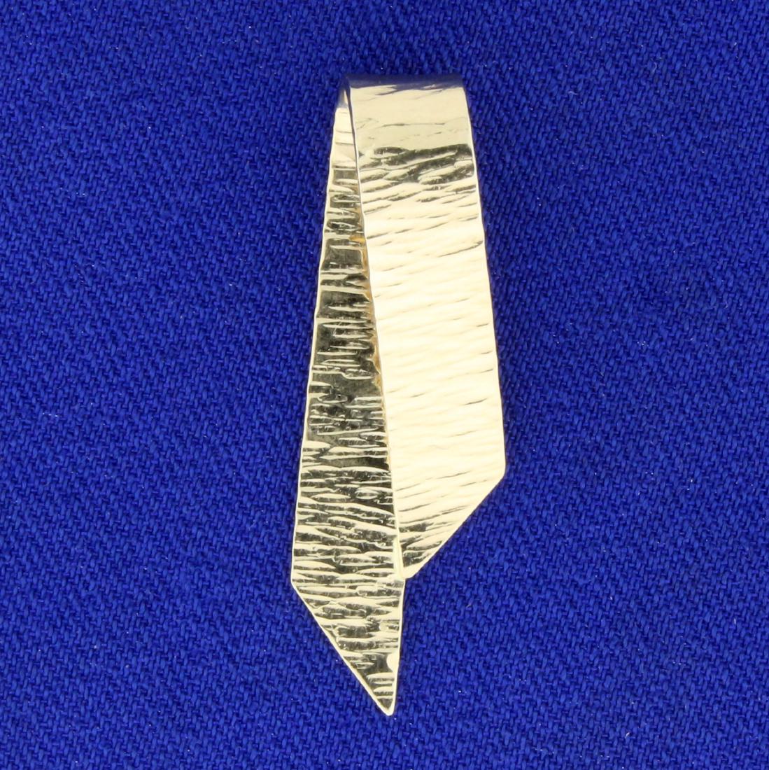 Ribbon Design Slide or Pendant in 14k Yellow Gold: In 14K Yellow Gold. 1 1/4 inches long. Textured Finish. 3.4g.