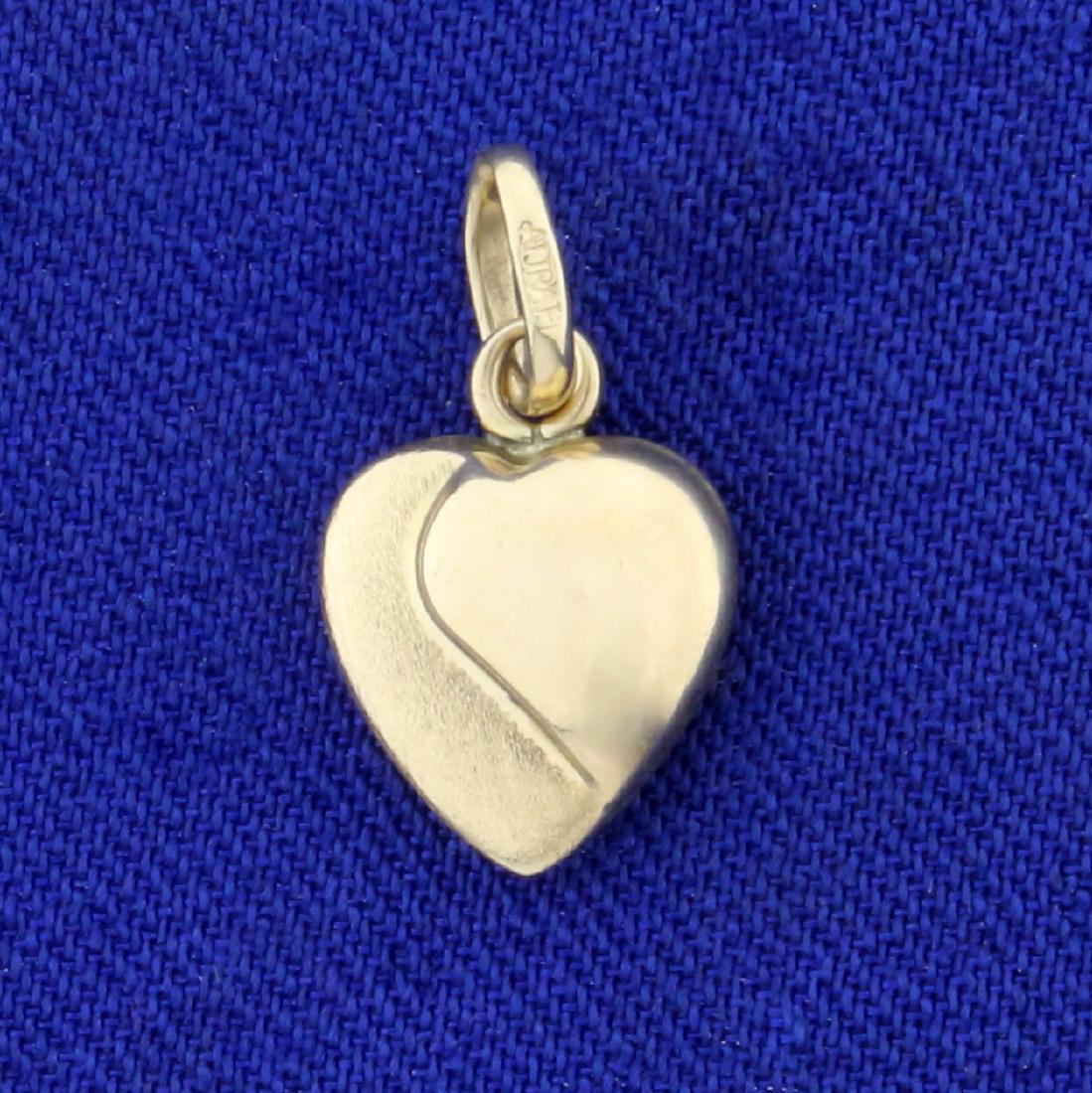 Heart Charm in 14K Yellow Gold: In 14K Yellow Gold. 3/4 inch long with bale. 0.7g