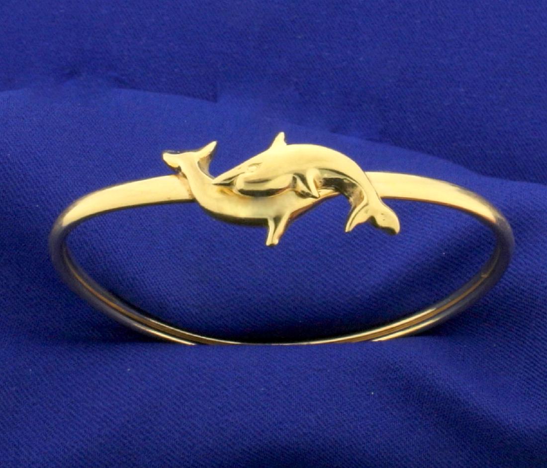Dolphin Bangle Bracelet in 14k Yellow Gold: In 14k yellow gold. 2 1/4" diameter. Bangle opens for easy putting on/taking off. 3.5mm wide. 9.3g.