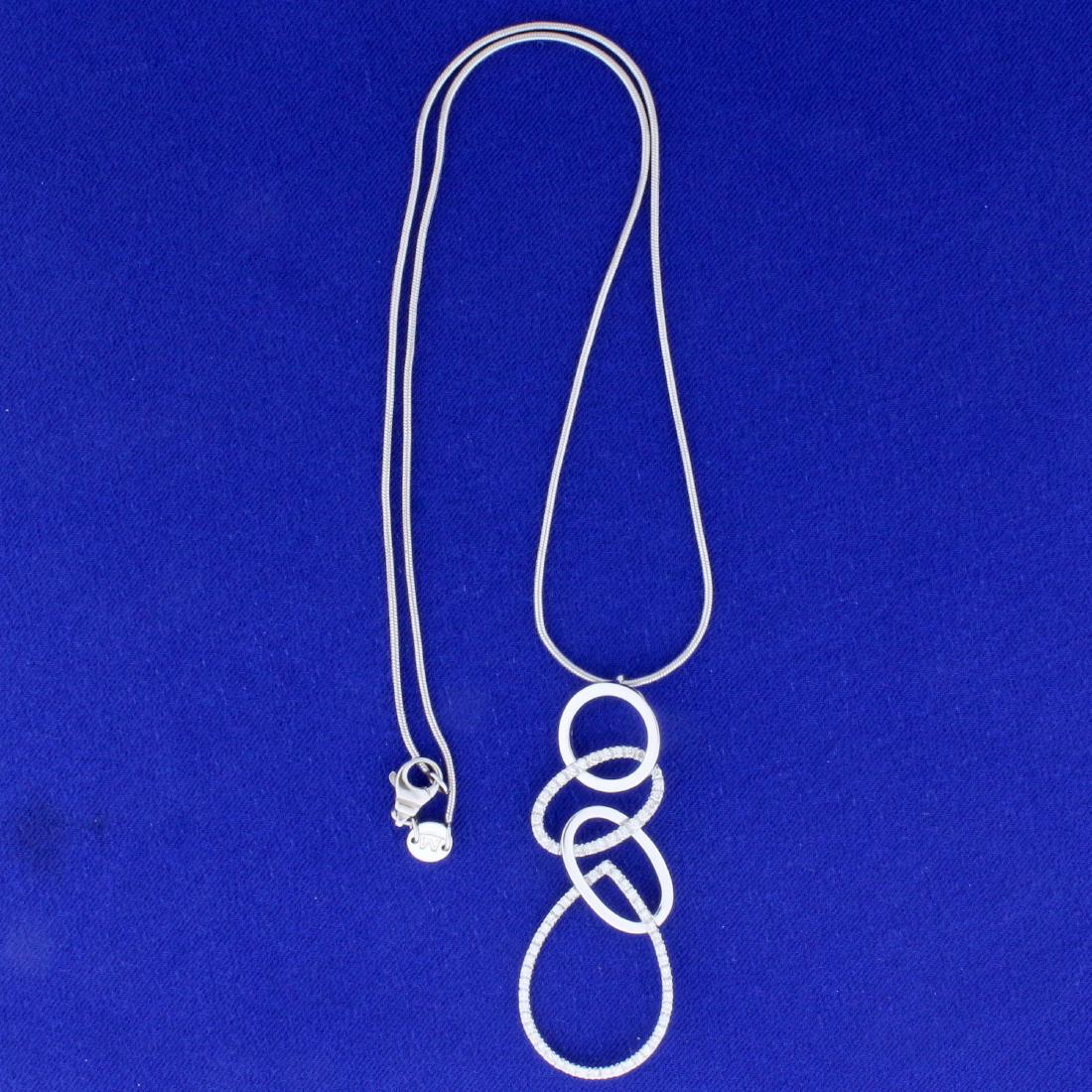 Movado Designer Diamond Necklace in 18K White Gold: In 18K White Gold. Contains seventy 1/2pt high quality Diamonds, VS clarity/F color. Pendant is 2 1/8 inches long. Snake link chain is 18 inches long. 12.3g.