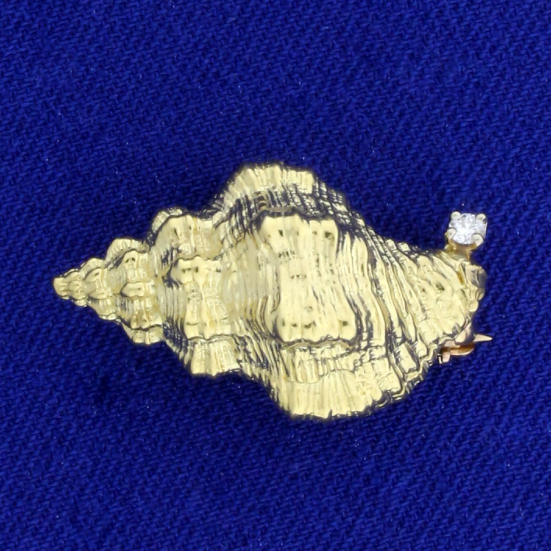 Seashell Diamond Pin in 18K Yellow Gold: In 18K Yellow Gold. 1 inch long. Contains a high quality .03ct round brilliant cut Diamond, VS clarity/F color. 6.1g.