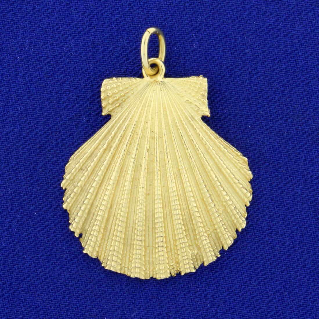Large Scallop Seashell Pendant or Charm in 18K Yellow: In 18K Yellow Gold. 1 1/16 inches wide, 1 7/16 inches long. Detailed design on shell makes it appear to glisten. 6.1g.