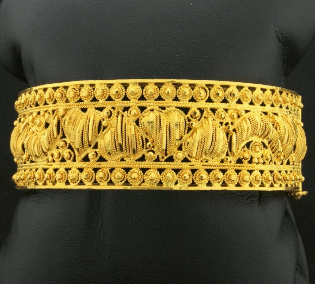 22K Yellow Gold Heavy Bangle Bracelet with Heart and: In 22K Yellow Gold. 21mm wide. Screw safety clasp. Hinges open/close. 2 1/4 inch inside diameter. Hand Crafted in Dubai. 52.4g