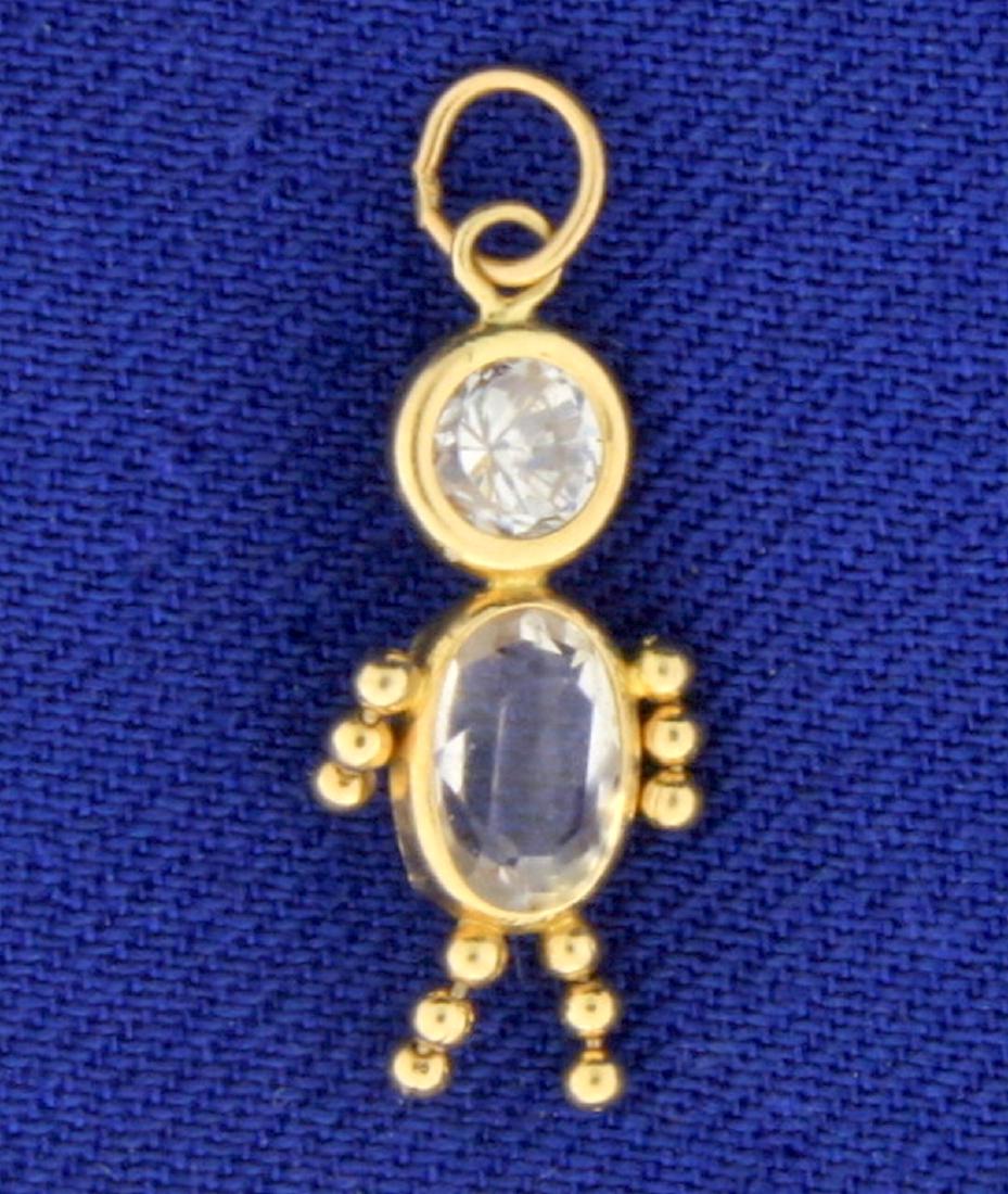 Child Charm in 14k Yellow Gold: In 14k yellow gold. Contains two CZ gemstones with lots of sparkle. 3/4 inch long, with bale. 0.7g.