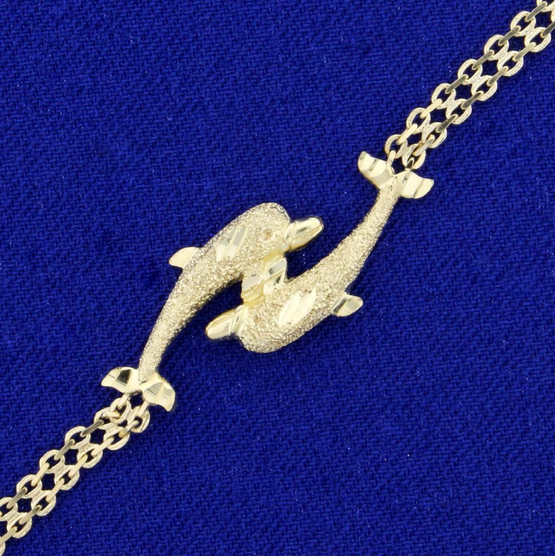 7 Inch Dolphin Bracelet in 14K Yellow Gold: In 14K Yellow Gold. 7 inches long with spring clasp. Chain is 3mm wide. Dolphin design measures 1 inch wide and 1/2 inch tall. Sparkle finish on dolphin. 2.7g.