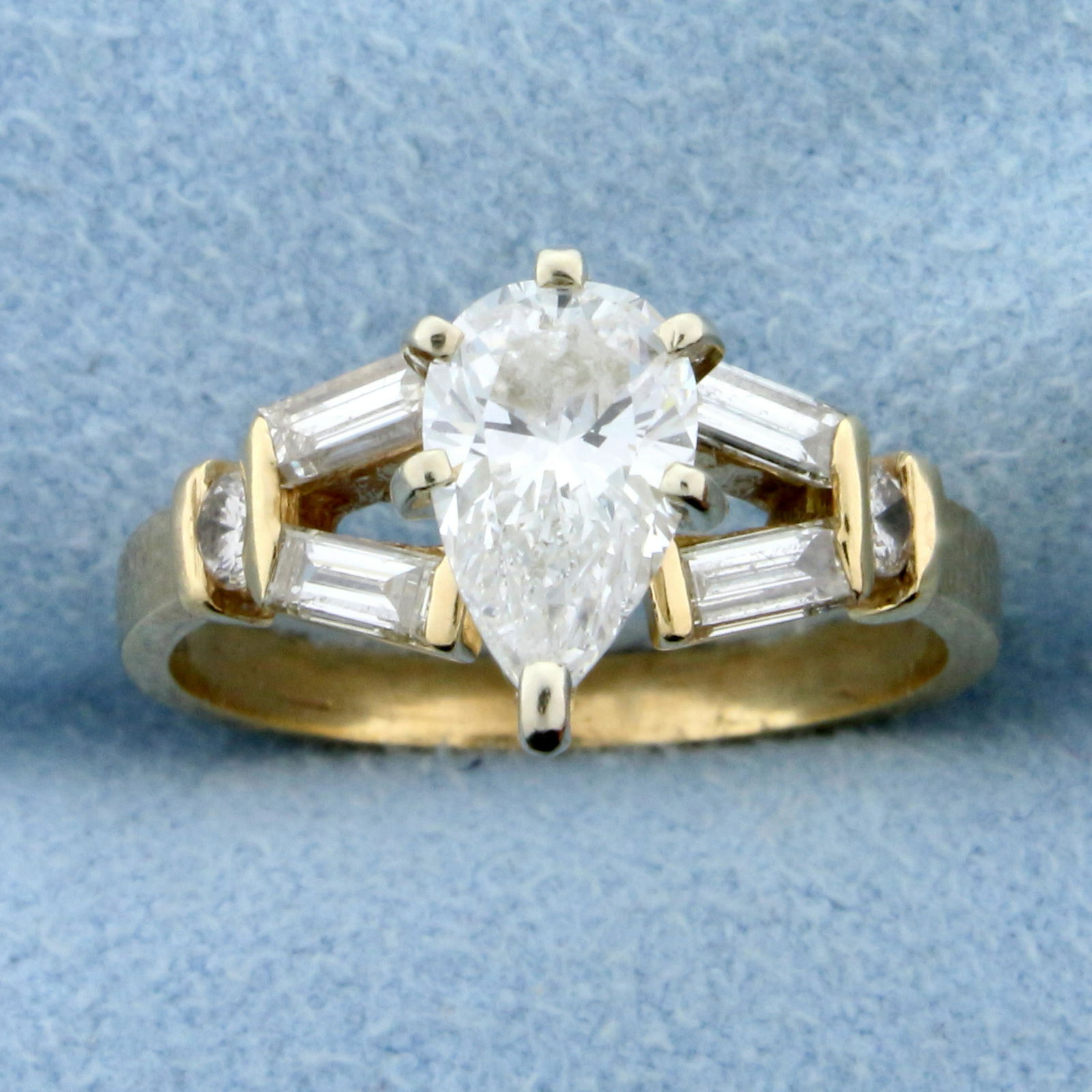 1.5ct TW Pear Diamond Engagement Ring in 14K Yellow: In 14K Yellow Gold. Contains a high quality 1 ct pear diamond. Also contains four high quality .09ctbaguette and two .05ct round brilliant diamonds. All diamonds are SI1 clarity/H color. Size 6 1/2. 3