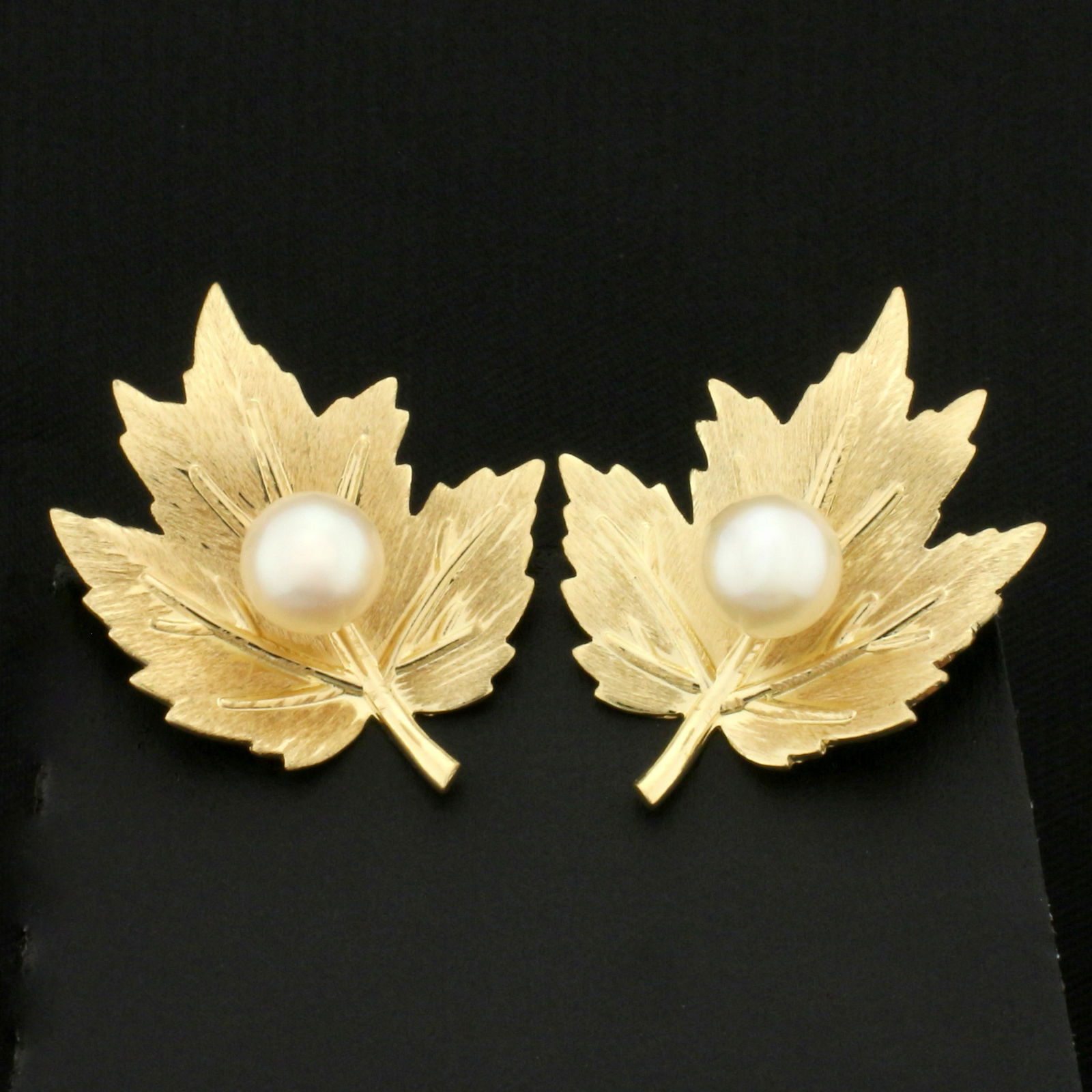 Screw Back Maple Leaf Pearl Earrings in 14K Yellow Gold: In 14K Yellow Gold. Each earring contains one high quality natural 6mm cultured Akoya Pearl with great color and luster. 1 inch long, 7/8 inch wide. Screw-back for non-pierced ears. 5.6g.