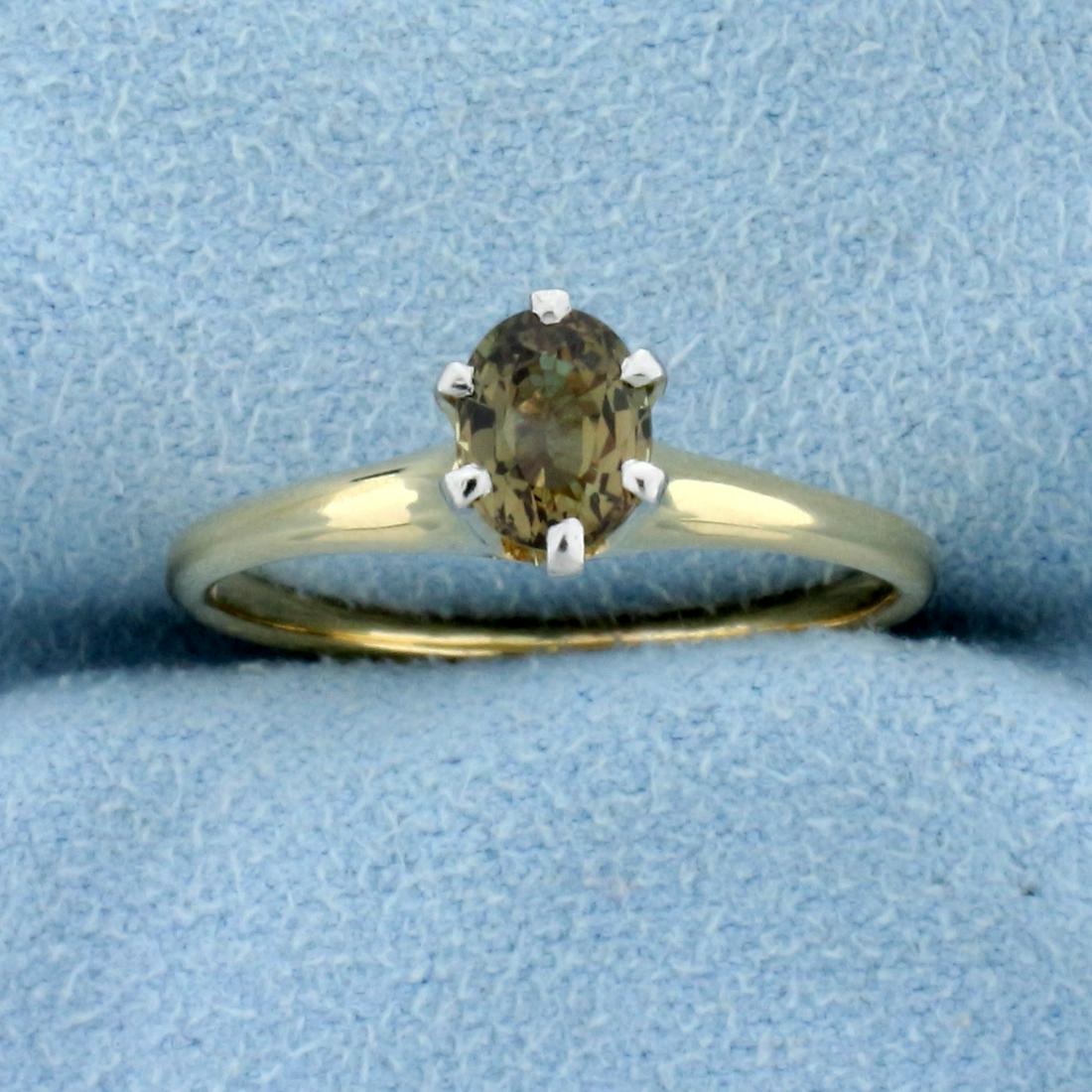 1/2ct Solitaire Alexandrite Ring in 14K Yellow Gold: In 14K Yellow Gold. Contains one high quality natural 6 x 5mm oval gemstone that changes color from green to golden brown color depending on light source and excellent clarity. Size 7 1/2. 2.4g.