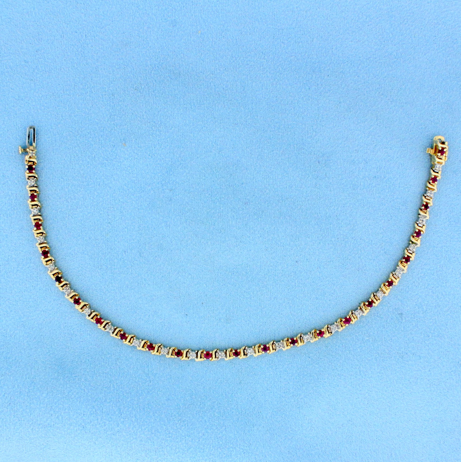 1ct TW Ruby and Diamond Tennis Bracelet in 14K Yellow: In 14K Yellow Gold. Contains twenty-three high quality natural .04ct Ruby gemstones with bright red color. Also contains twenty-three high quality 1/2pt Diamonds. 7 1/2 inches long. 3mm wide. With saf