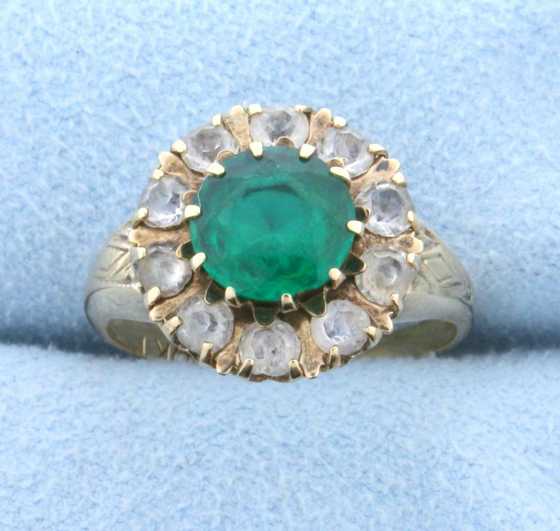 1.5ct Synthetic Emerald and Diamond Flower Ring in 10K: In 10K Yellow Gold. Contains one high quality synthetic 1.5ct Emerald gemstone with vibrant green color and excellent clarity. Also contains ten high quality 3mm synthetic diamonds. Size 6. 2.7g.