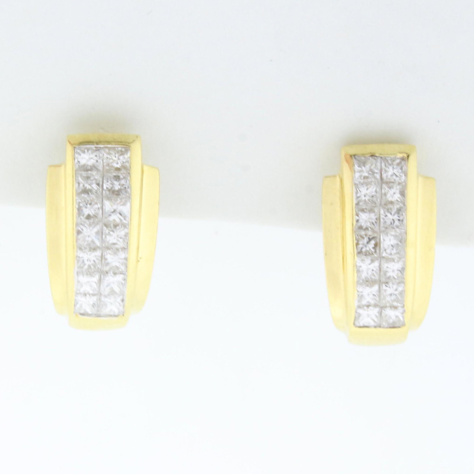 1ct TW Invisible Set Princess Diamond Earrings in 14K: In 14K Yellow Gold. Each earrings contains fourteen high quality princess cut diamonds ranging from .03 to .05cts each, VS clarity/F color. 1 inch long, 1/4 inch wide. With French Omega backs for pier