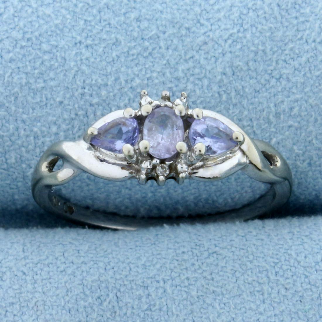 Tanzanite and Diamond Ring in 10K White Gold: In 10K White Gold. Contains one high quality natural 4 x 3mm oval cut and two 4 x 3mm pear cut Tanzanite gemstones with beautiful blue purple color and excellent clarity. Also contains two high qualit