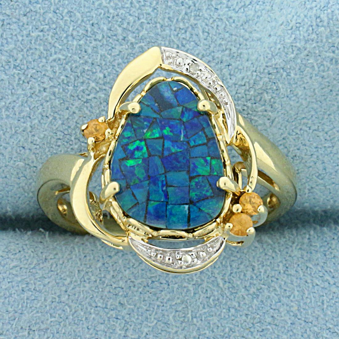 Black Opal Doublet, Heliodor, and Diamond Ring in 10K: In 10K Yellow Gold. Contains one high quality natural 12x9mm pear shaped mosaic doublet black opal gemstone with vivid blue and green color. Also contains three high quality natural 2mm Heliodor gemst
