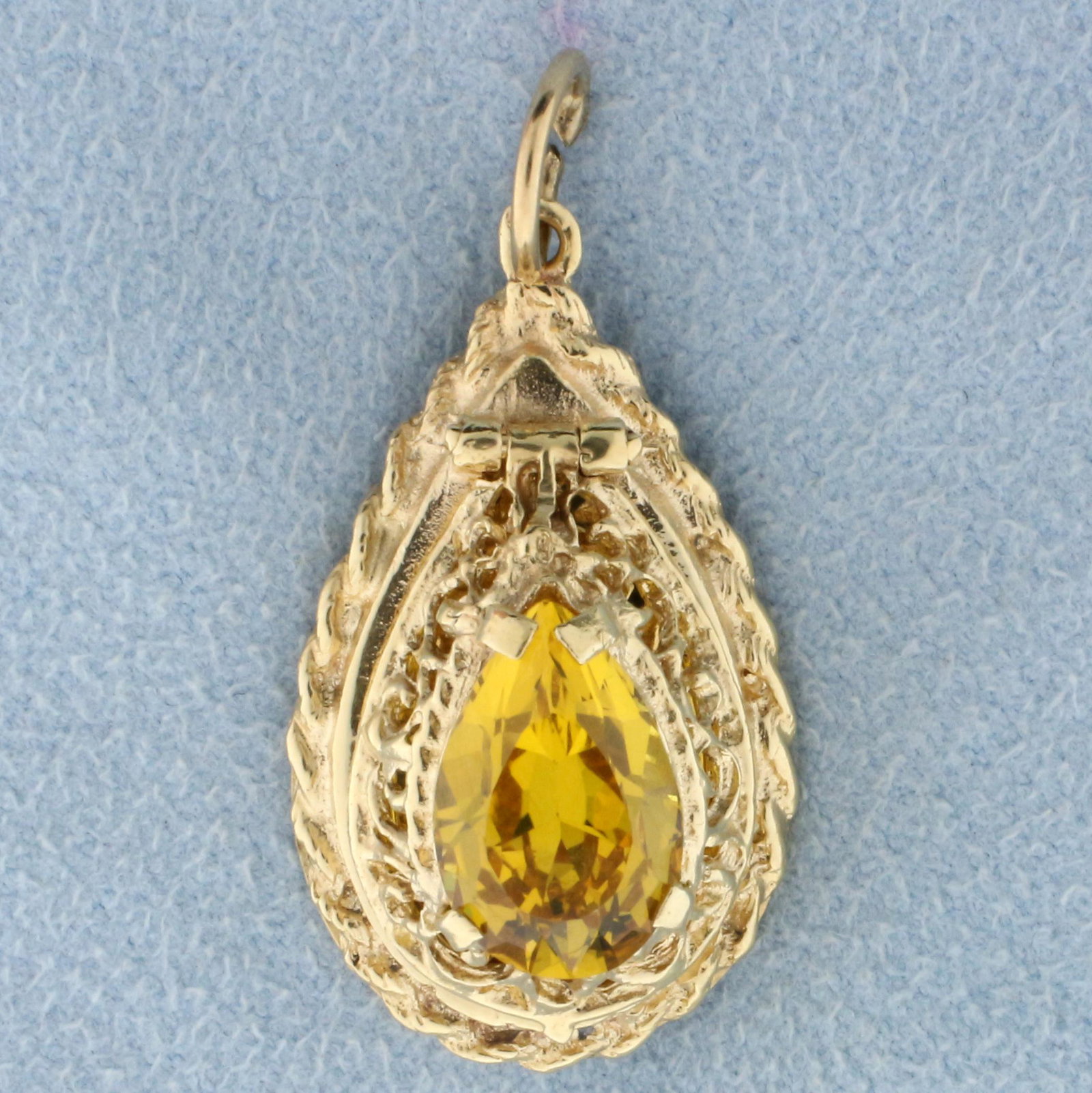 Vintage 4ct Yellow Sapphire Locket Pendant in 14K: In 14K Yellow Gold. Contains one high quality 4ct pear cut Yellow Sapphire gemstone with beautiful canary yellow color and excellent clarity. 1 5/16 inches long with jump ring. 5/8 inch wide. 5.2g