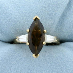 Smoky Topaz and CZ Ring in 14K Yellow Gold: In 14K Yellow Gold. Contains a high quality natural 16 x 7mm 3.5ct high quality marquise shaped Smoky Topaz gemstone with warm color and excellent clarity. Also contains two 6mm baguette CZ gemstones