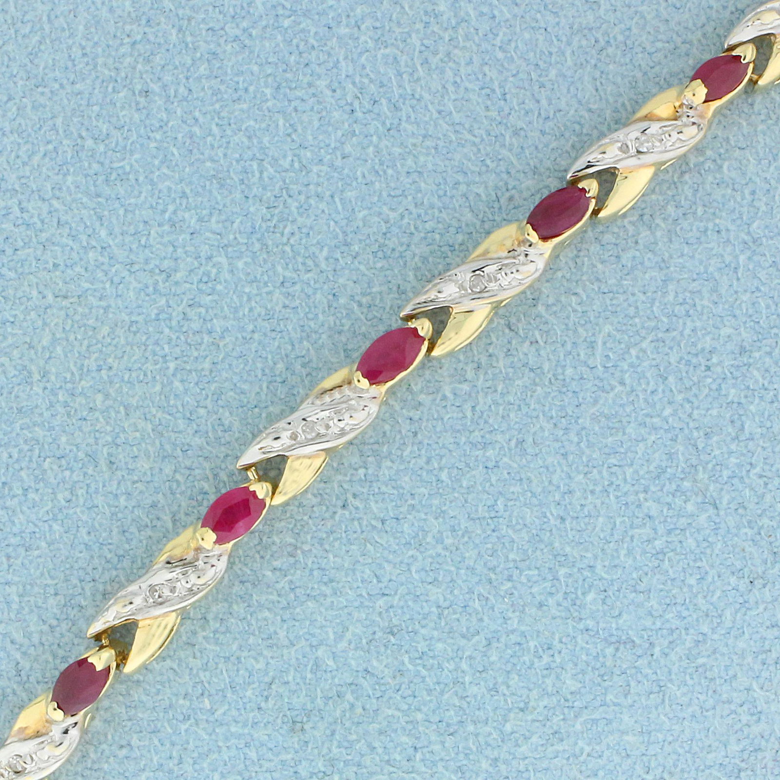 2ct TW Ruby and Diamond Line Bracelet in 10K Yellow and: In 10K Yellow and White Gold. Contains seventeen high quality natural 4 x 2mm marquise cut Ruby gemstones with beautiful bright ruby red color. Also contains seventeen high quality 1/2pt Diamonds. 7 3