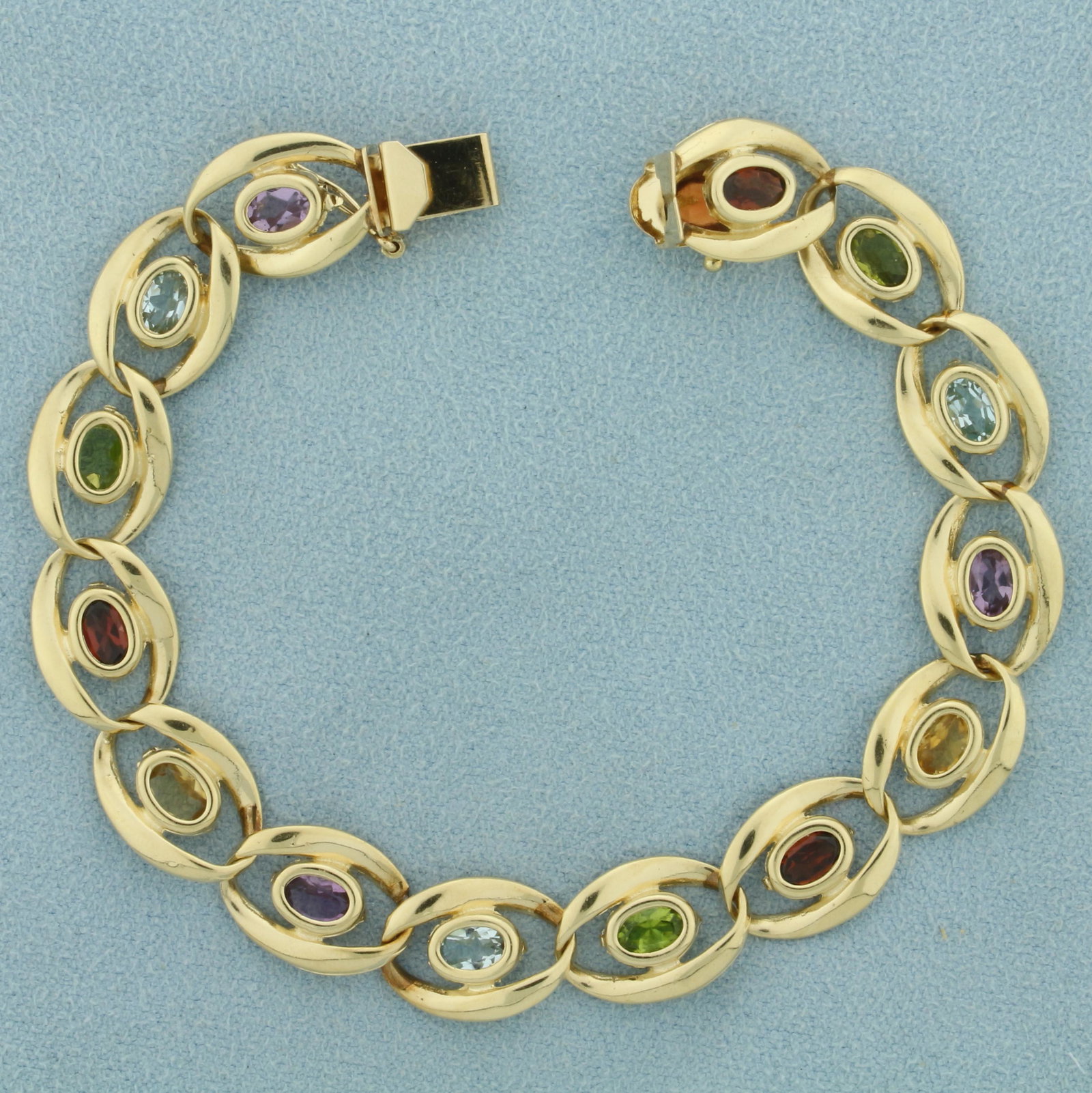 Multi-Colored Semi-Precious Gemstone Bracelet in 14K: In 14K Yellow Gold. Contains fourteen natural high quality 5x3mm oval shaped gemstones including three Amethyst, three Sky Blue Topaz, three Peridot, three Garnet, and two Citrine. All gemstones have 