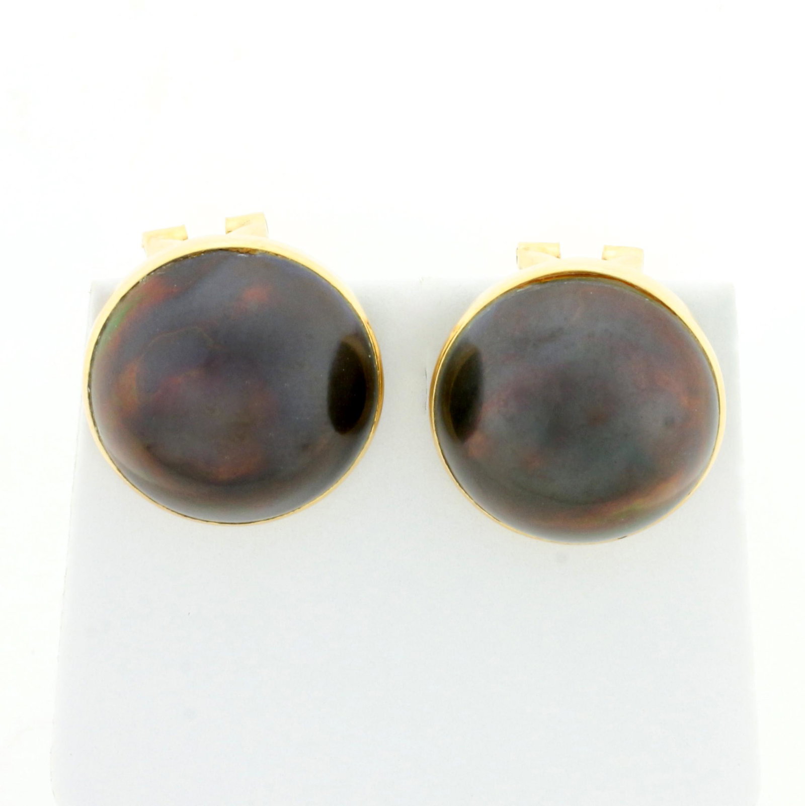 17mm Tahitian Pearl Earrings in 14K Yellow Gold: In 14K Yellow Gold. Each earring contains one high quality natural 17mm Tahitian Pearl with pink and green peacock colored overtones. With French clip backs for pierced ears. 9.4g.