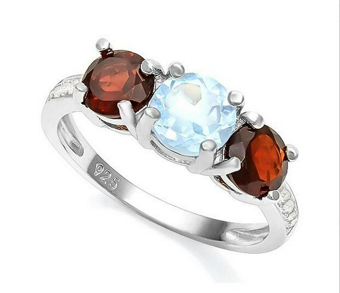 Classic Blue Topaz & Garnet 3-Stone Ring in Sterling: Round cut 1ct sky blue topaz gemstone ring, accented with 1.2ctw round cut garnets and white sapphire in the band. Size 7. Set in platinum over sterling silver, 2.7g.