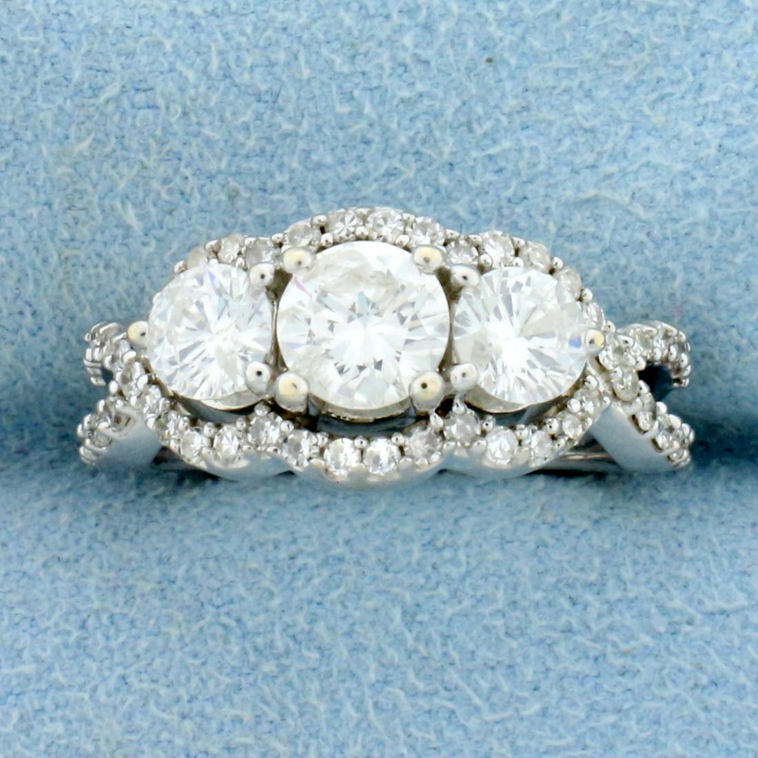 2ct TW 3 Stone Halo Diamond Engagement Ring or: In 14K white gold. The center stone is a high quality .7 ct round brilliant diamond, F color/ SI-2 clarity. The two side diamonds are .4 ct each, also F color/ SI-2 clarity. Also contains fifty .01 ct