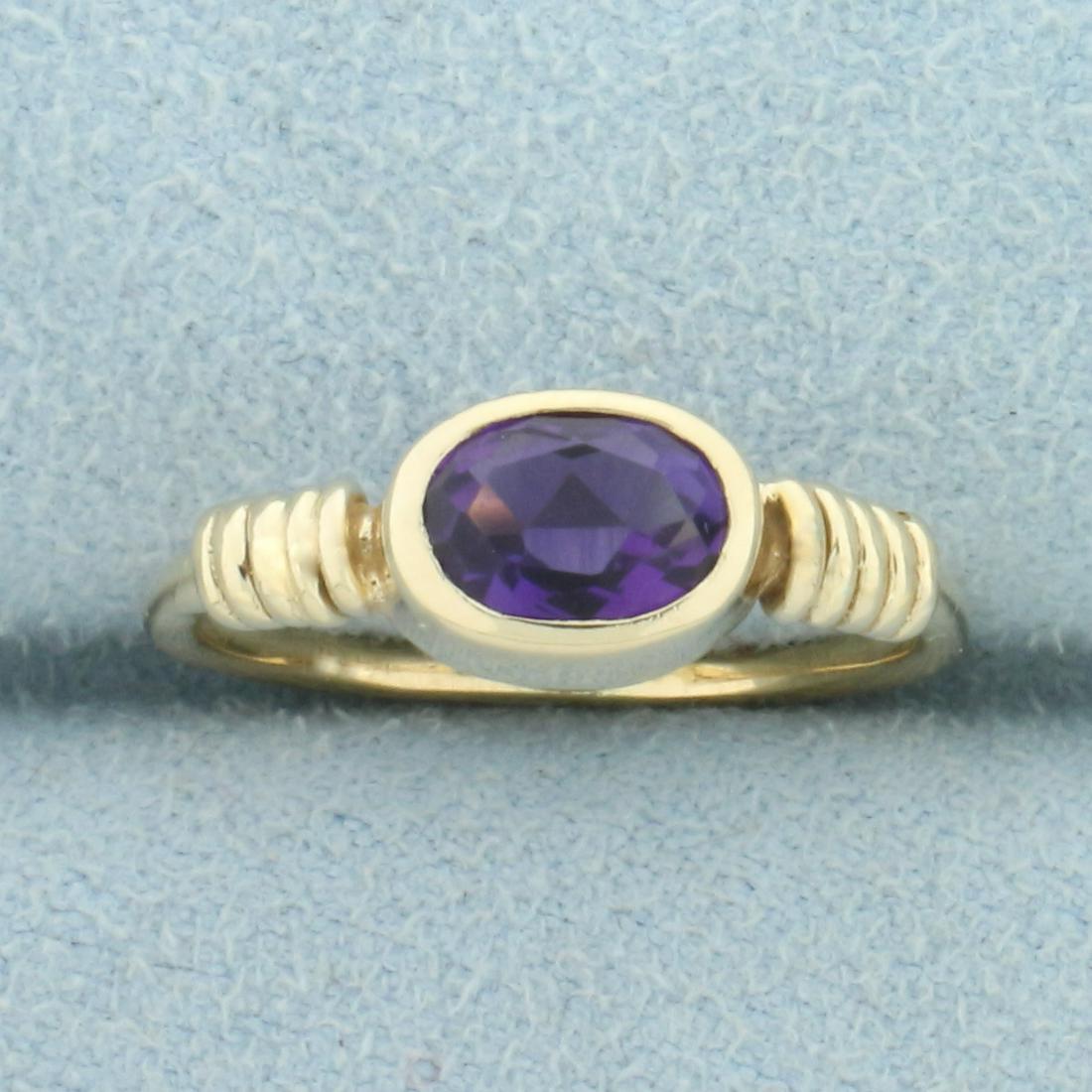 Amethyst Solitaire Pinky Ring in 14K Yellow Gold: In 14K Yellow Gold. Contains a high quality natural 6.5 x 5mm oval Amethyst gemstone, approximately 2/3ct, with vibrant purple color and excellent clarity. Size 4 1/2. 2.1g
