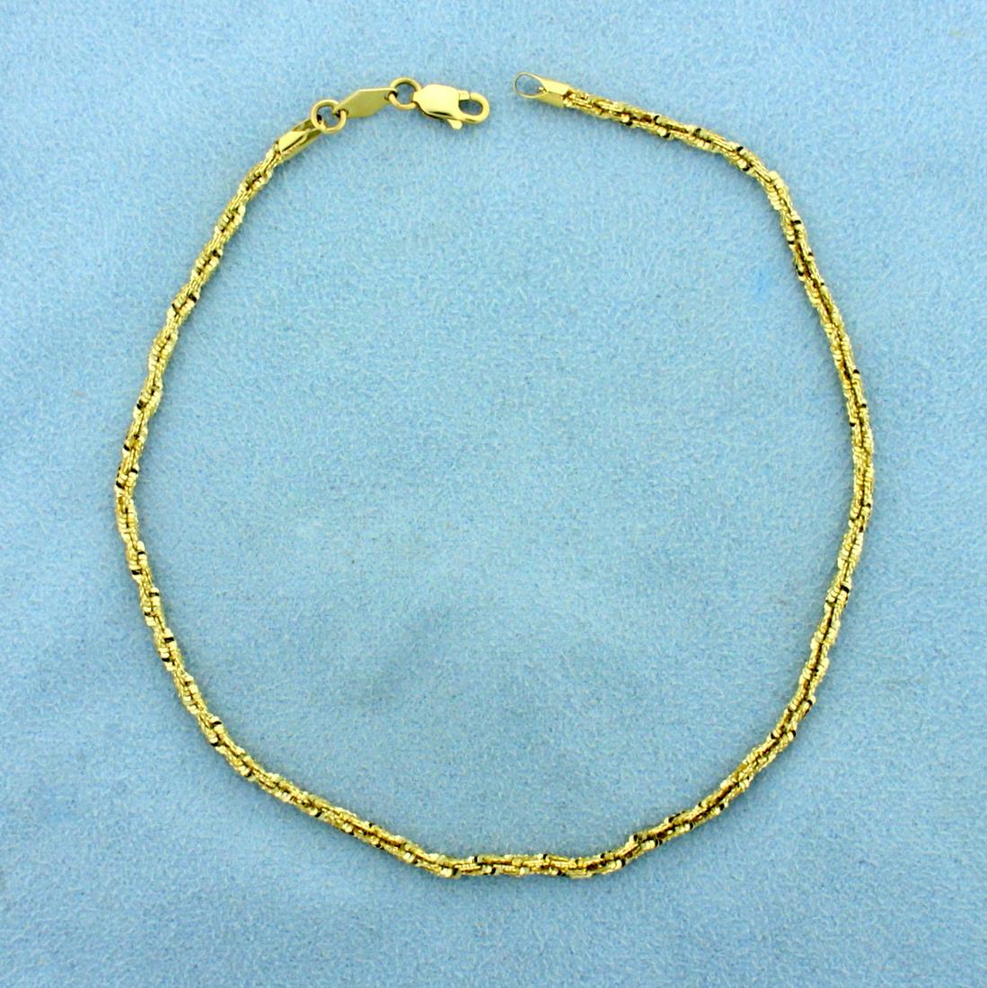 9 3/4 Inch Tinsel Link Anklet in 14K Yellow Gold: In 14K Yellow Gold. Links catch the light and sparkle like tinsel. 9 3/4 inches long. 2.2mm wide. Lobster clasp. 3.5g