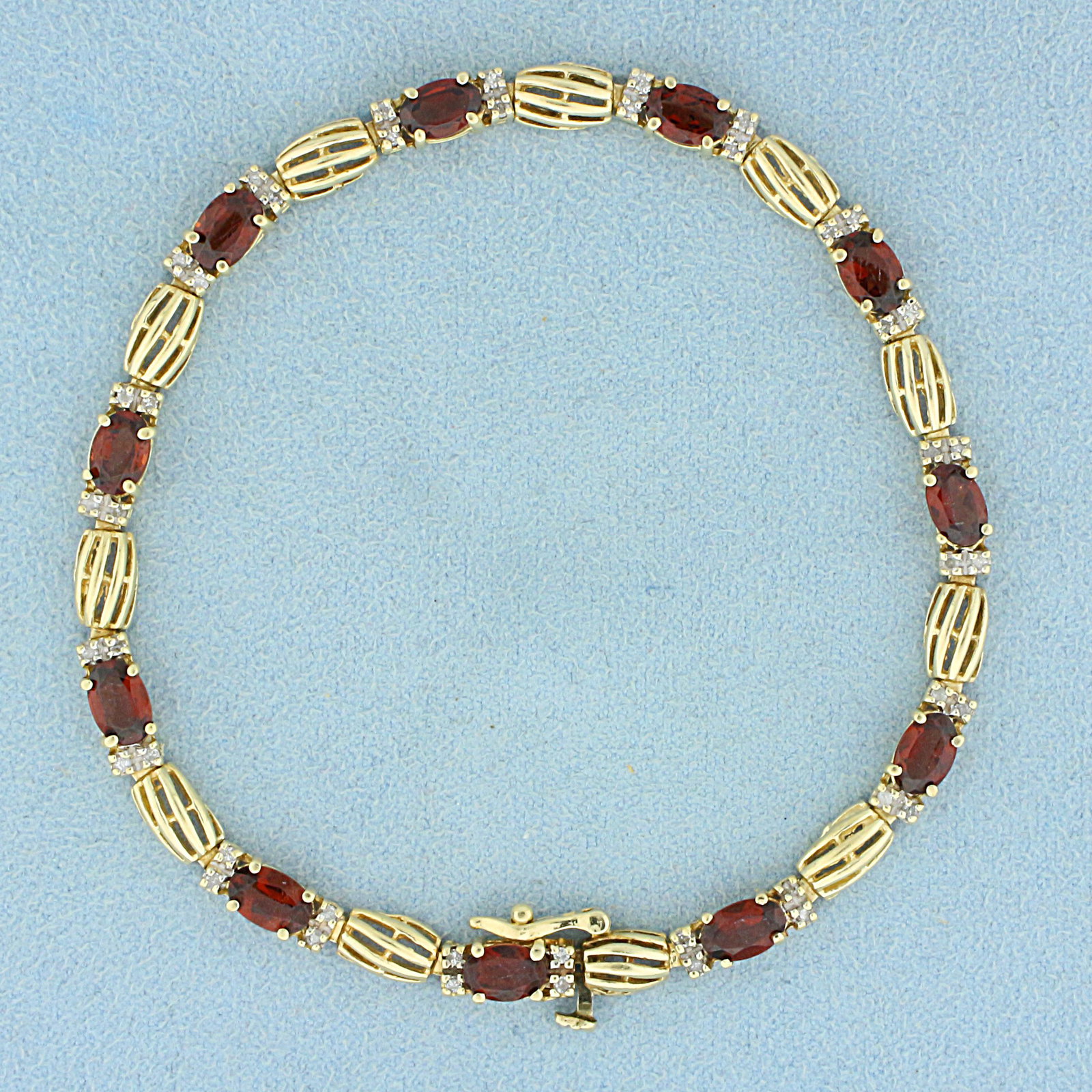 6ct TW Garnet and Diamond Line Bracelet in 14K Yellow: In 14K Yellow Gold. Contains eleven high quality natural 6 x4mm oval cut Garnet gemstones with rich color and excellent clarity. Also contains forty- four high quality 1/2pt Diamonds. 7 1/2 inches lon