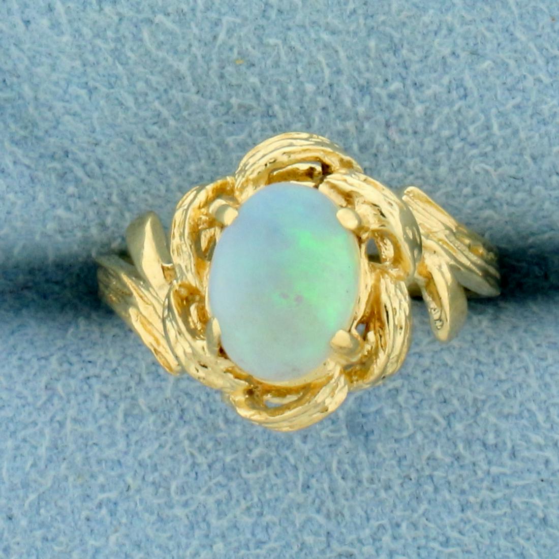 Opal Solitaire Ring in 14K Yellow Gold: In 14K Yellow Gold. Contains a high quality 8x6mm oval cut cabochon Opal gemstone with intense play of color with flashes of purple and green. Size 4 1/2. 2.8g