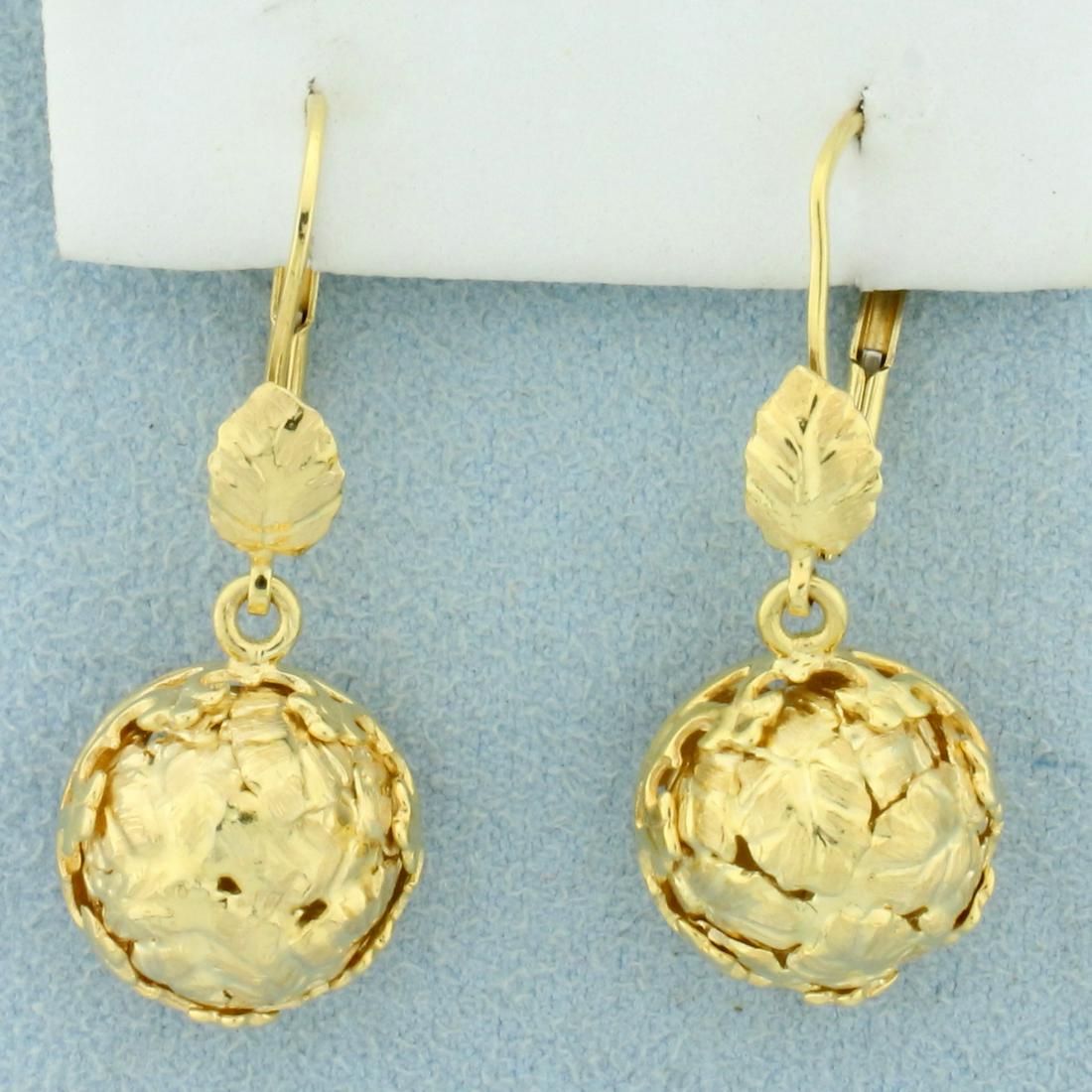Italian-Made Leaf and Flower Design Drop Earrings in: In 14K Yellow Gold. Earrings are beautifully crafted with domed leaf design on front of half sphere, and flower carved out on the lever backs. 6.1g